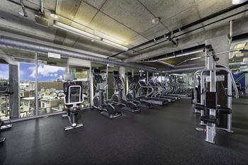 a spacious fitness center with cardio equipment and a view of the city at The Shay, District of Columbia 20001